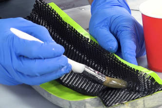 Impregnando el tejido de carbono con resina a pincel