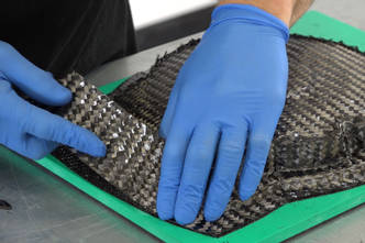 Manos colocando el tejido de carbono en el molde